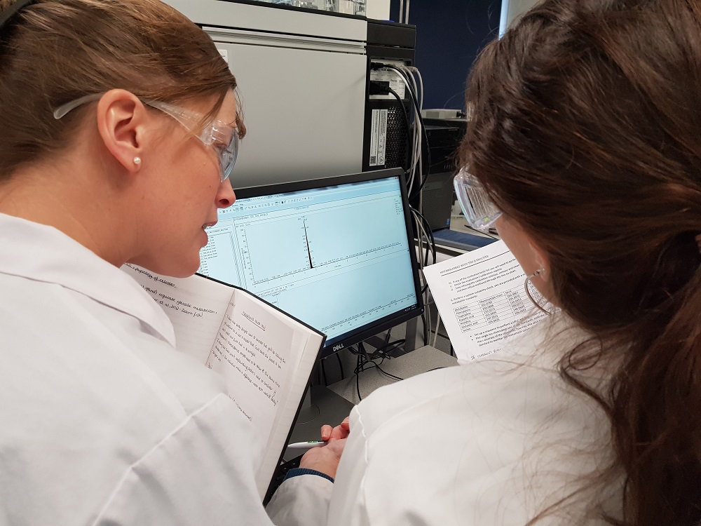 Trainees in the laboratory looking at a mass spectrometry read-out